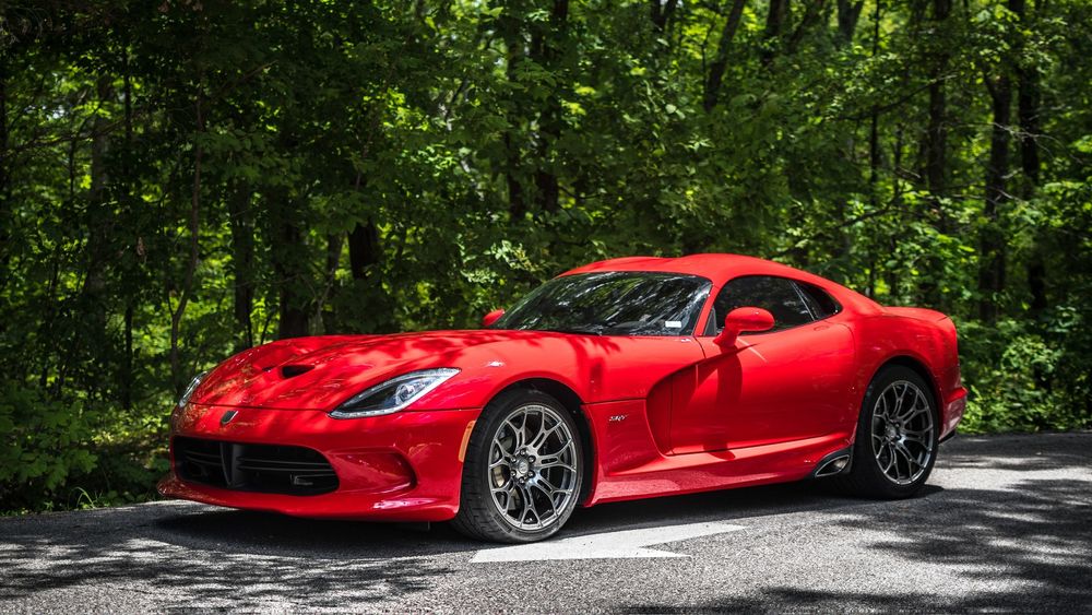 Обои для рабочего стола Красный суперкар Dodge Viper SRT стоит на дороге в лесу