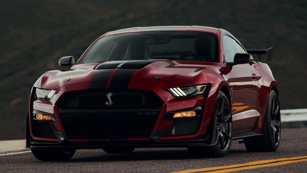Обои для рабочего стола Красный автомобиль Ford Mustag Shelby GT стоит на дороге