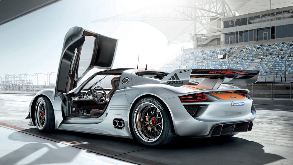 Обои для рабочего стола Спорткар Porsche 918 RSR стоит на гоночной трассе с открытой дверью