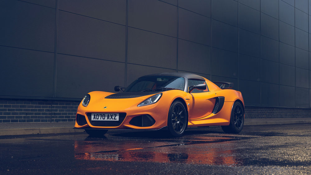 Обои для рабочего стола Желтый спорткар Lotus Exige Sport 390 стоит на мокром асфальте