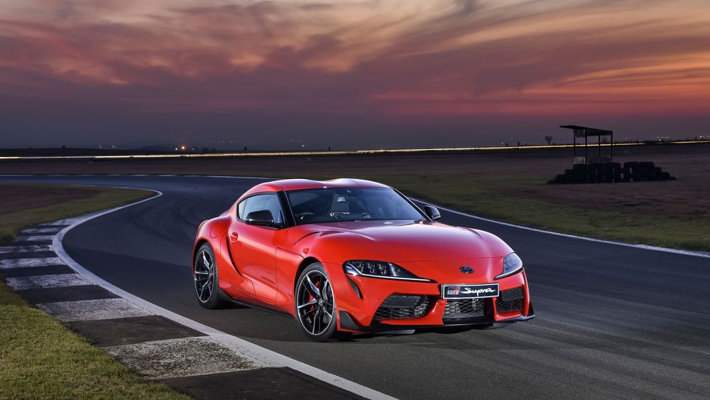 Обои для рабочего стола Красный автомобиль Toyota Supra на гоночной трассе