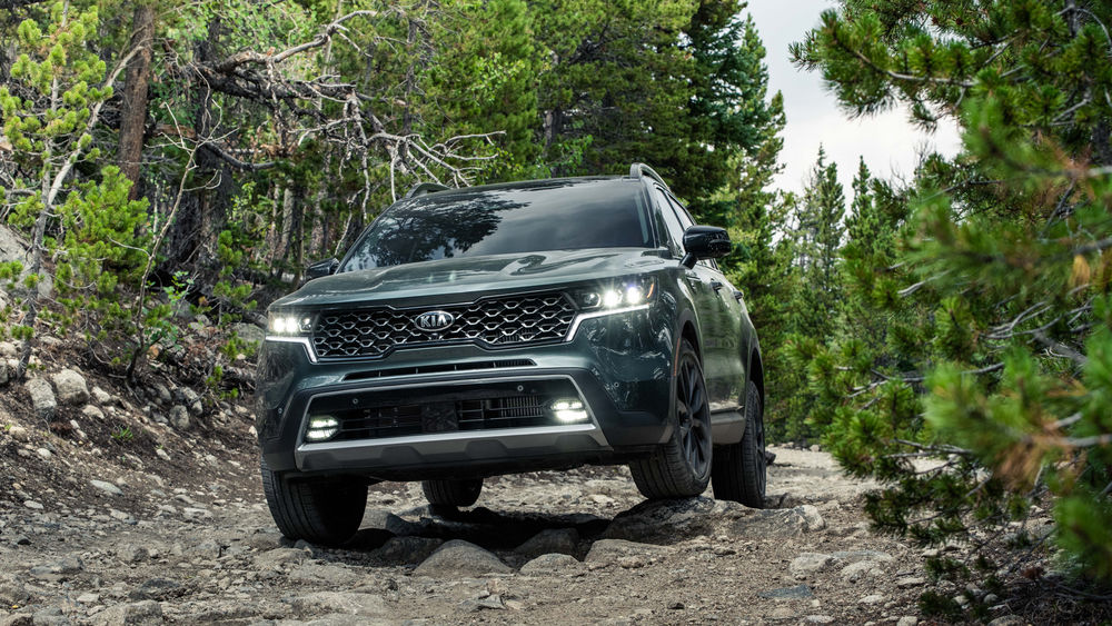 Обои для рабочего стола Зеленый кроссовер Kia Sorento едет по горной дороге