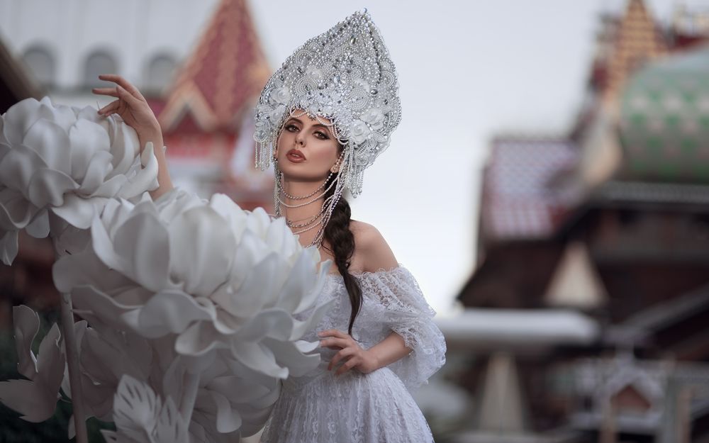 Обои для рабочего стола Модель Елена Борисенкова в кокошнике и белом платье стоит у белых цветов, фотограф Олег Демьянченко