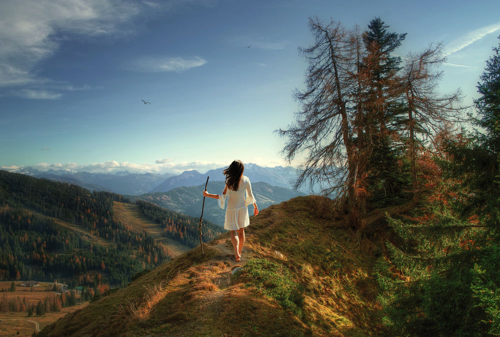 Обои для рабочего стола Девушка с палкой в руке стоит на холме. Фотограф Sergii Vidov