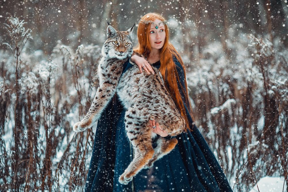 Обои для рабочего стола Девушка с рысью на руках стоит под снегопадом. Фотограф Савенкова Александра