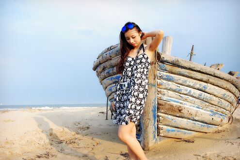 Обои на рабочий стол Девушка с фотоаппаратом стоит у лодки, by maya_7966