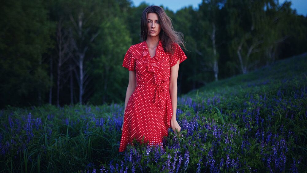 Обои для рабочего стола Модель Александра в красном платье стоит на цветущем поле, фотограф Sergey Fat