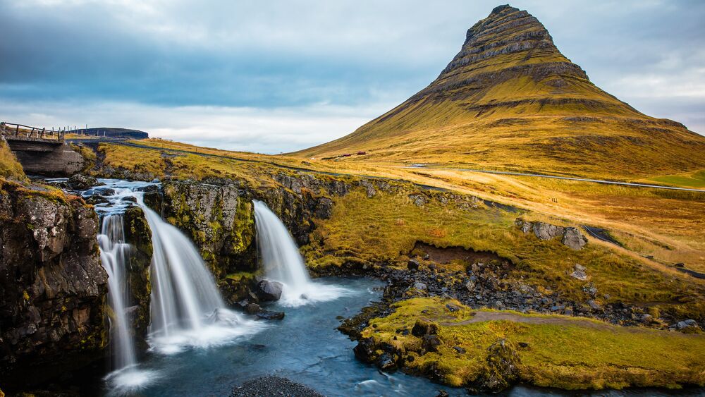Обои для рабочего стола Водопады на фоне горы Kirkjufell / Киркьюфетль в западной части Исландии, покрытой пожухлой травой