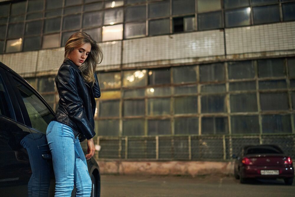 Обои для рабочего стола Модель Вика в джинсах и кожаной курточке стоит у авто, фотограф Sergey Bogatkov