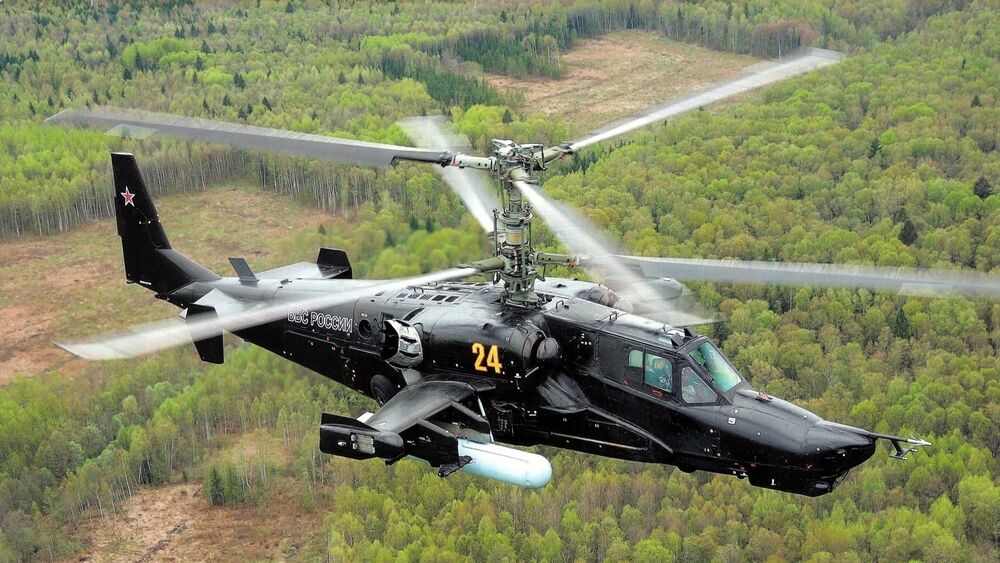 Обои для рабочего стола Боевой ударный вертолет пролетает над лесом