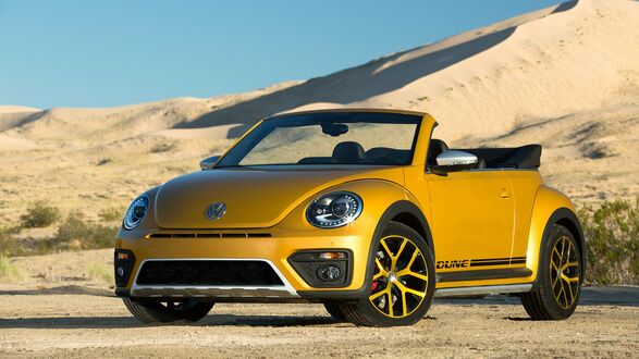 Обои на рабочий стол Желтый Volkswagen New Beetle на фоне песчаных дюн