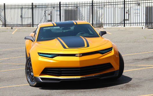 Обои на рабочий стол Желтый Chevrolet Camaro на парковке