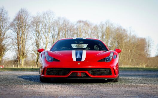 Обои на рабочий стол Красный Ferrari 458 speciale спереди, на фоне деревьев