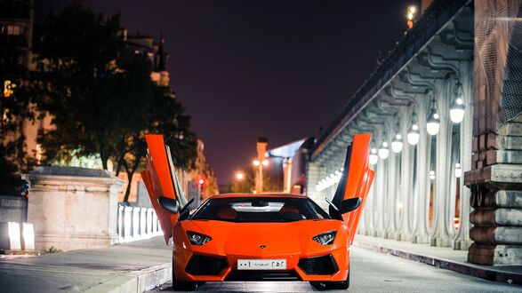 Обои на рабочий стол Красный Lamborghini Aventador на ночной улице города с открытыми дверьми
