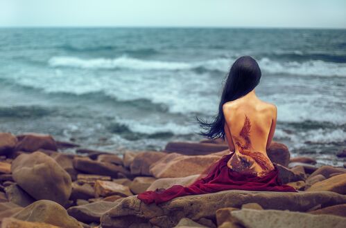 Обои на рабочий стол Модель смотрит на океан с татуировкой на спине