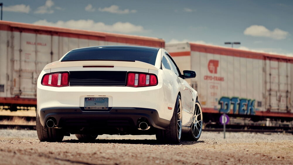 Обои для рабочего стола Белый Ford Mustang на фоне железнодорожных вагонов, сзади