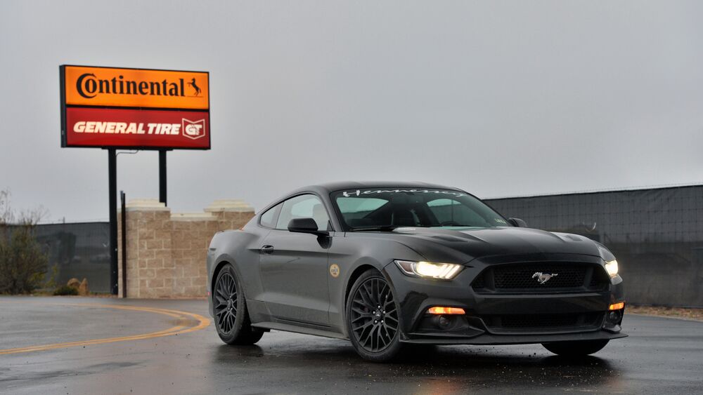 Обои для рабочего стола Черный Ford Mustang GT 750 на мокром асфальте у указателя