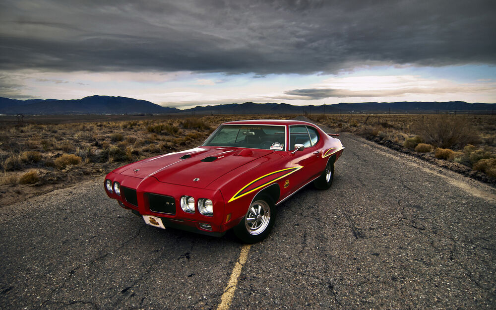 Обои для рабочего стола Красный Pontiac GTO 1969 на дороге в степи