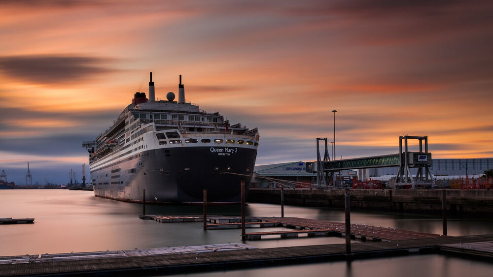 Обои для рабочего стола Круизный лайнер Queen Mary 2 стоит в порту на фоне закатного неба, England, Southampton