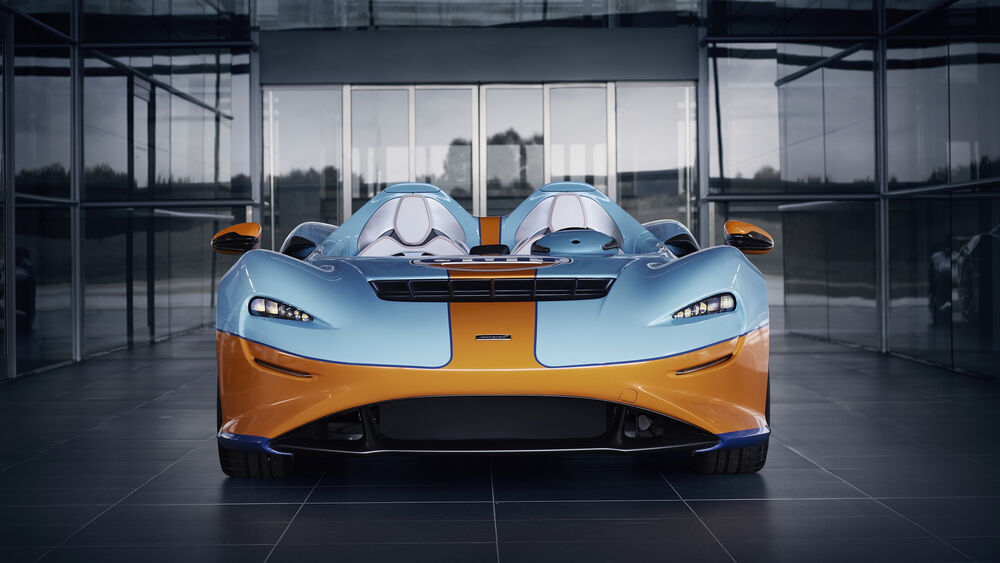 Обои для рабочего стола Голубой с коричневой полосой MCLAREN Elva у здания
