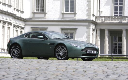 Обои на рабочий стол Aston Martin v8 Vantage стоит припаркованный возле особняка