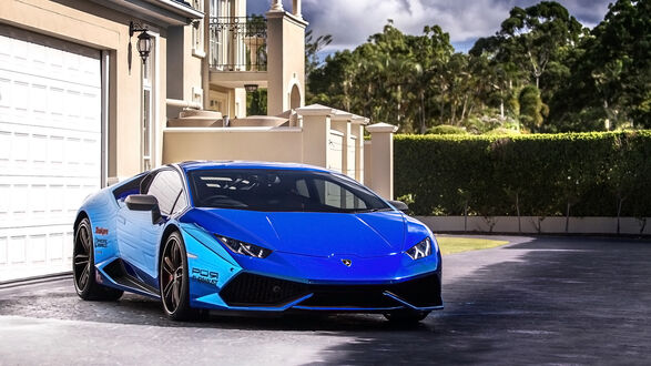 Обои на рабочий стол Спортивный автомобиль Lamborghini Huracan синего цвета припаркован возле гаража виллы