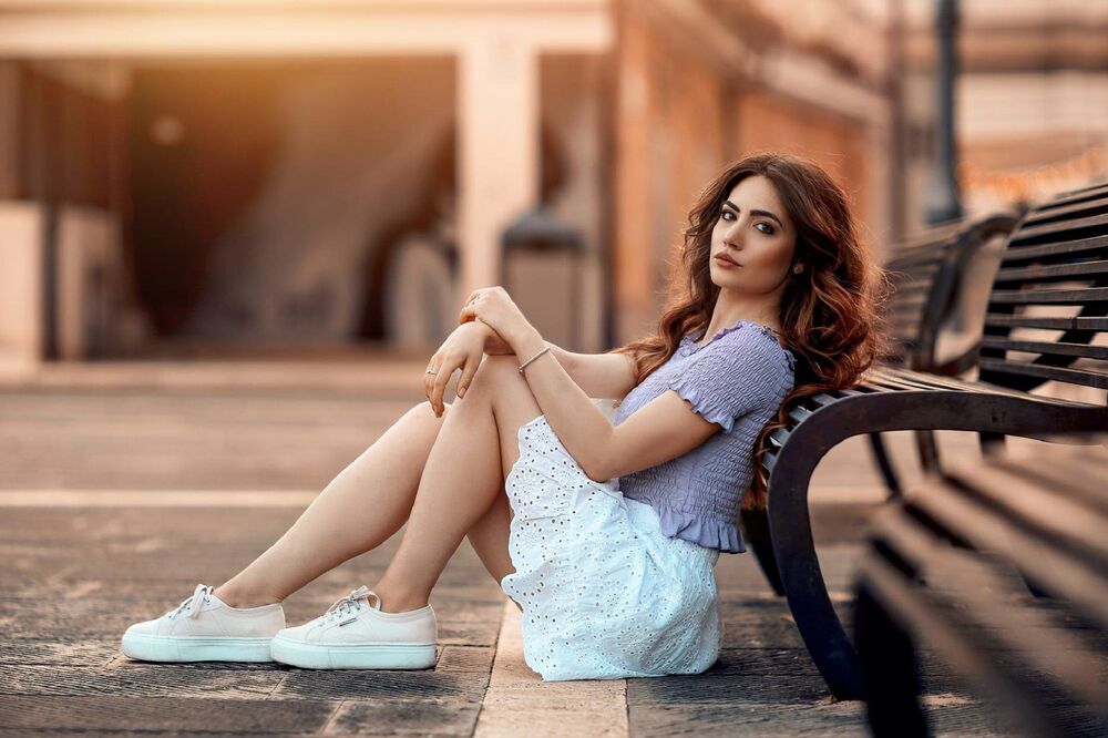Обои для рабочего стола Модель Arianna Storace сидит на асфальте у лавочки, фотограф Alessandro Di Cicco