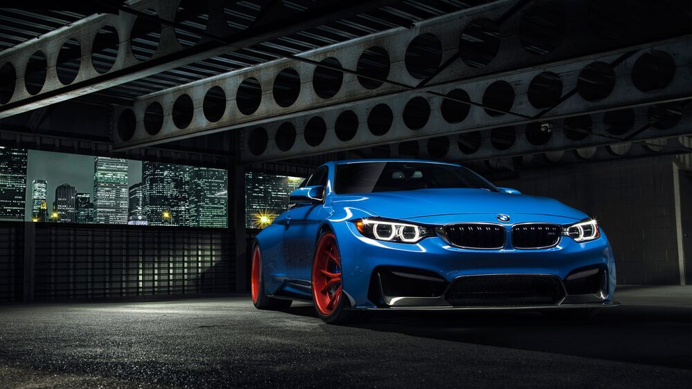 Обои для рабочего стола BMW m4 синяя ночью стоит на многоярусной парковки