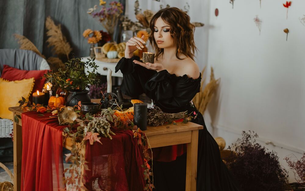 Обои для рабочего стола Девушка в черном длинном платье сидит за столом, держа в руке свечу, фотограф Буканова (Мизинова) Ульяна