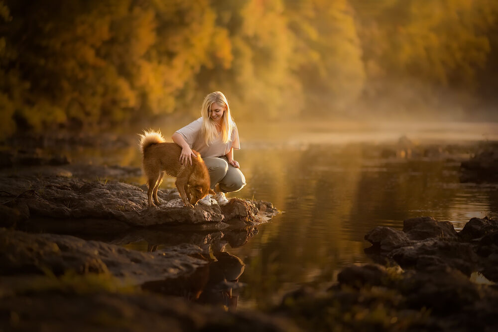 Обои для рабочего стола Девушка с собакой на берегу реки в осеннем лесу
