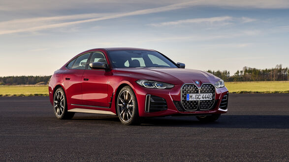 Обои на рабочий стол Красный BMW 4 Gran Coupe стоит на дороге на фоне поля
