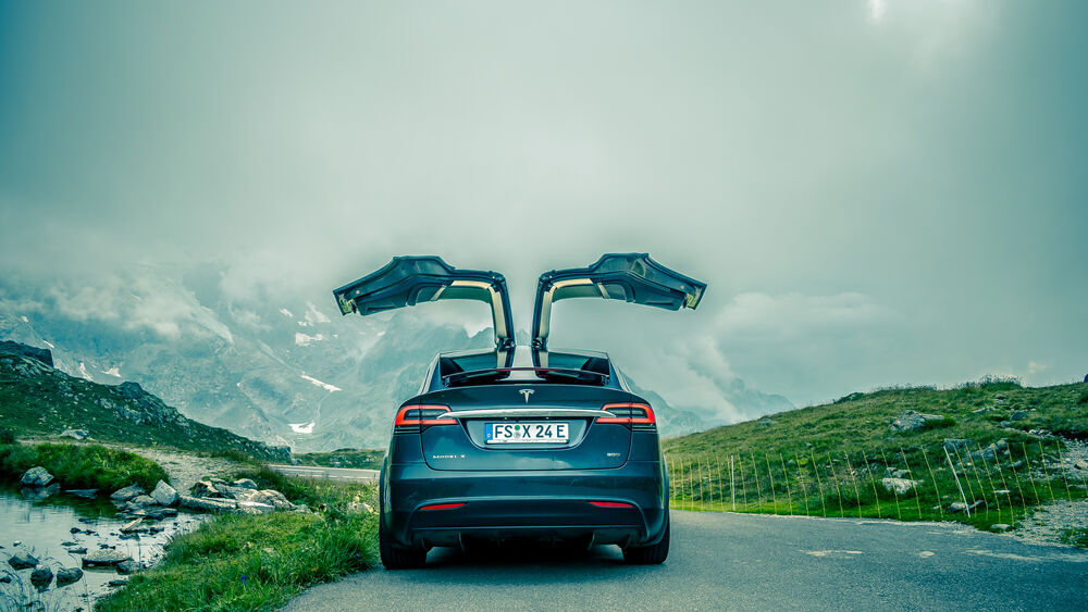 Обои для рабочего стола Tesla Model X, performance стоит на дороге с открытыми дверями