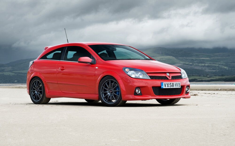 Обои для рабочего стола Автомобиль Vauxhall Astra VXR, стоящий на песке на фоне серых облаков