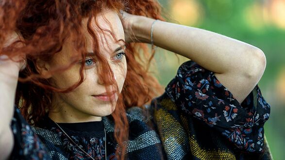 Обои на рабочий стол Модель Ксения Ратомских с рыжими волосами. подняла руки к голове в темном платье