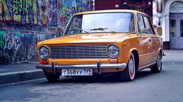 Обои на рабочий стол Желтый Ваз 2101 на улице у стены с граффити