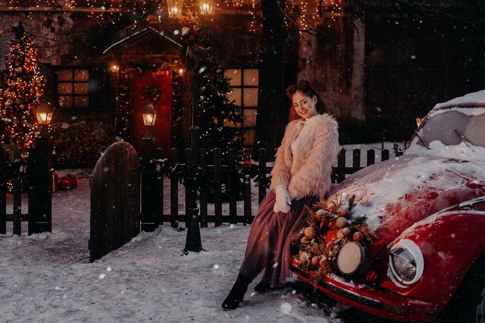 Обои для рабочего стола Ночная улица, новогодняя елка около дома и улыбающаяся девушка рядом с красной машиной