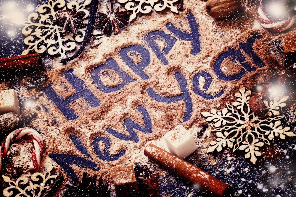 Обои для рабочего стола Надпись Happy New Year среди снежинок кубиков сахара и палочек корицы