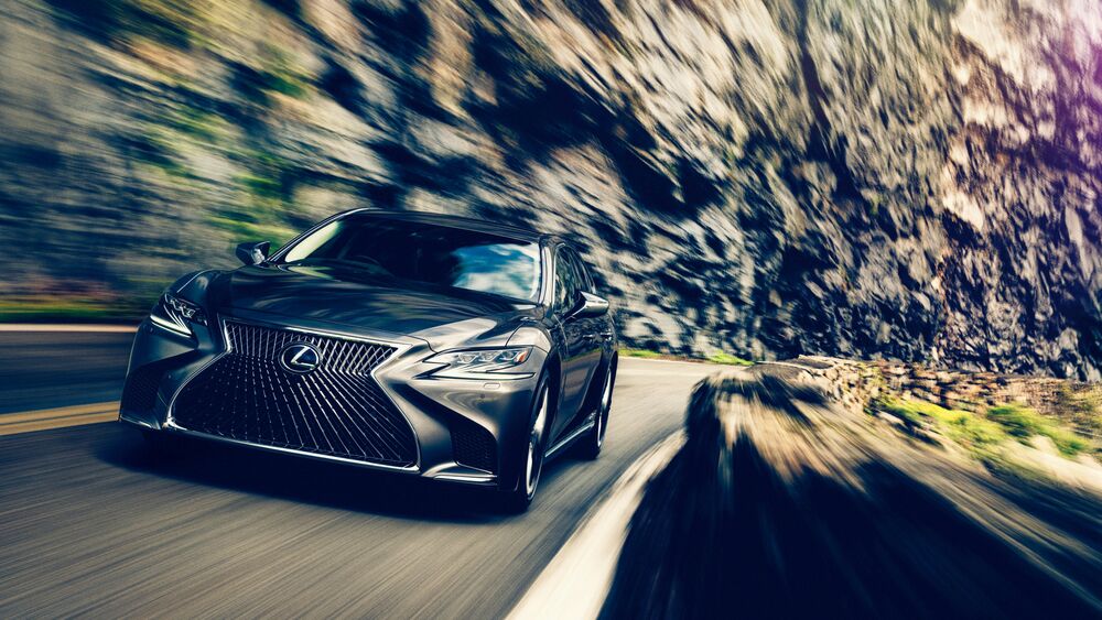 Обои для рабочего стола Lexus LS, темно серого цвета, мчится по трассе среди гор