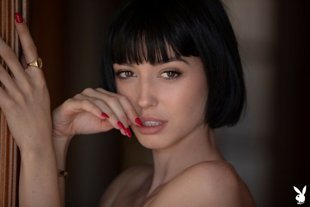 Обои для рабочего стола Брюнетка Sophia Sohnel с каре стоит у двери с рукой у лица