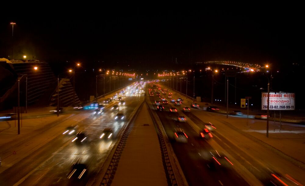 Обои для рабочего стола Движущиеся автомобили по магистрали уходящей огнями в черноту ночи