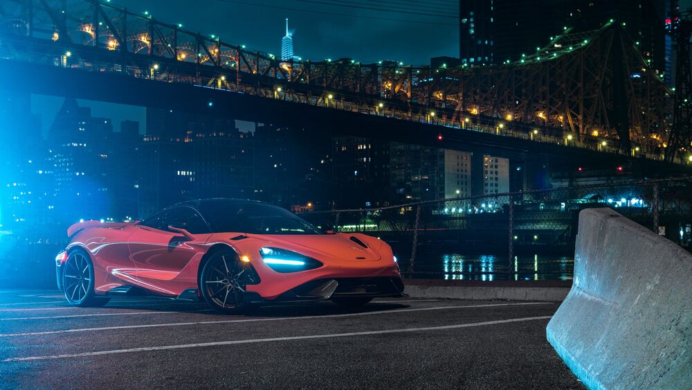 Обои для рабочего стола Mclaren 765lt оранжевого цвета стоит ночью на набережной возле моста