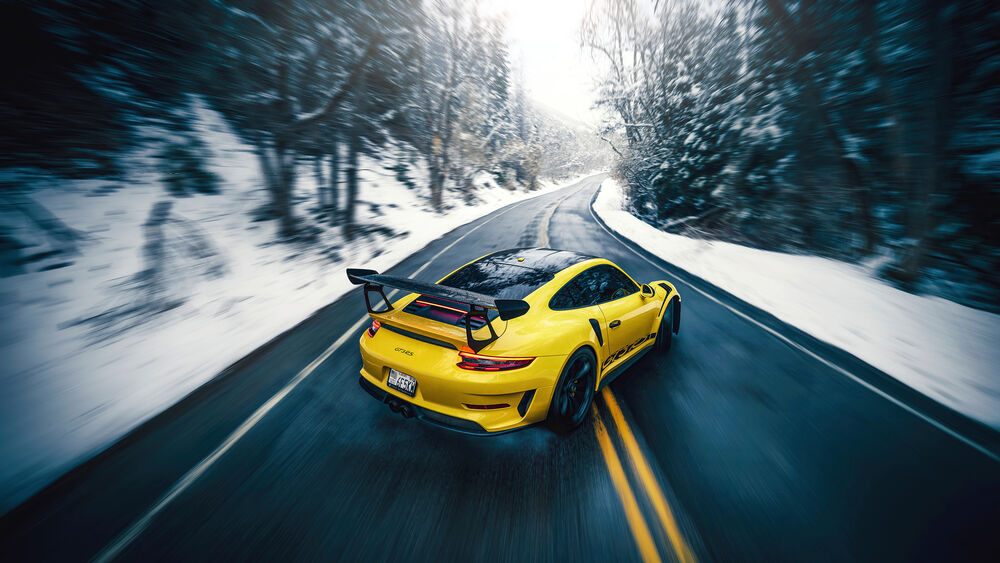 Обои для рабочего стола Porsche GT3 RS желтого цвета, мчится по заснеженной трассе