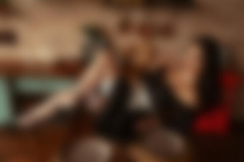 Обои на рабочий стол Модель в наряде горничной, белых чулках и туфлях сидит на столе