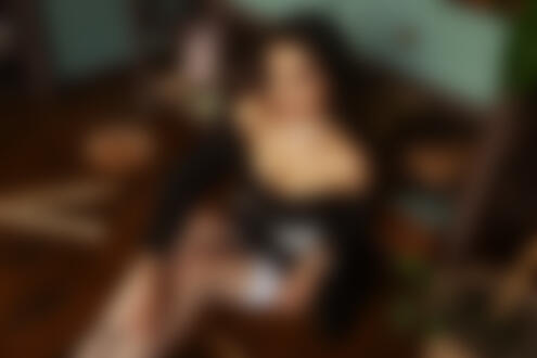 Обои на рабочий стол Модель в наряде горничной, белых чулках, с ленточкой н шее сидит на полу