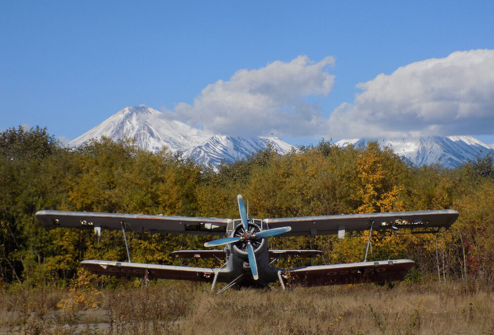 Обои для рабочего стола Ветеран Ан-2 доживает свои дни на полевом аэродроме на фоне заснеженных вершин