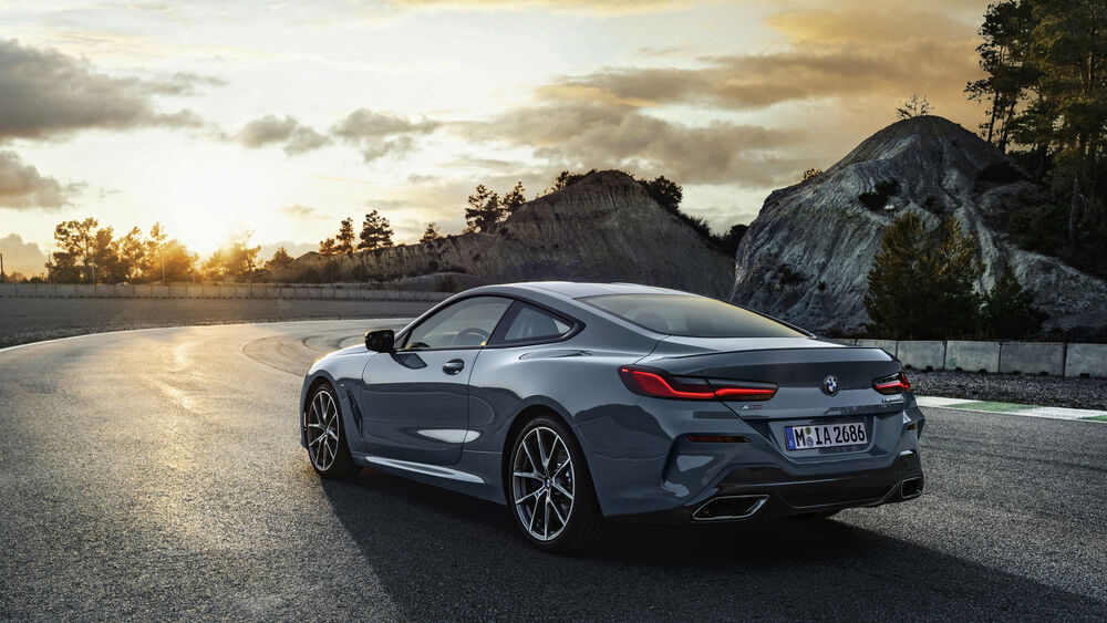 Обои для рабочего стола BMW 8 Series серого цвета сзади на трассе уезжает в вечерний закат