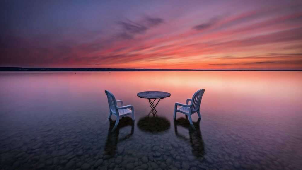 Обои для рабочего стола Два стула и стол на озере в воде в штиль на закате