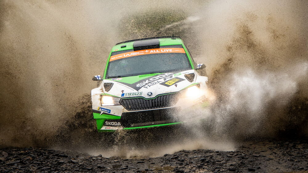 Обои для рабочего стола Раллийный автомобиль Skoda Fabia r5 evo в облаке брызг воды и грязи