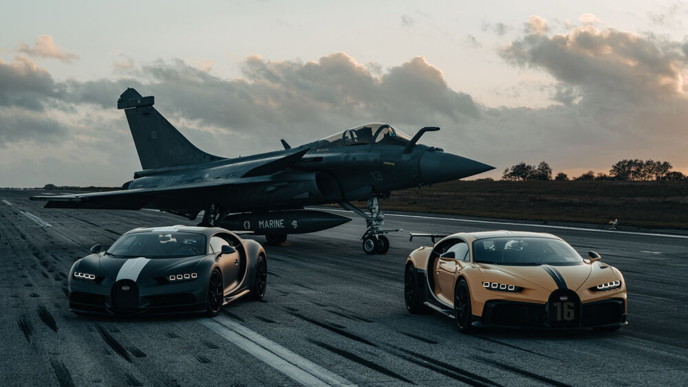 Обои для рабочего стола Два Bugatti Chiron и истребитель Rafale на взлетно-посадочной полосе на закате