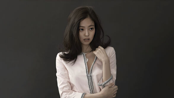 Обои на рабочий стол Ким Дженни / Kim Jennie из BLACKPINK в розовой кофте с распущенными волосами на темном фоне